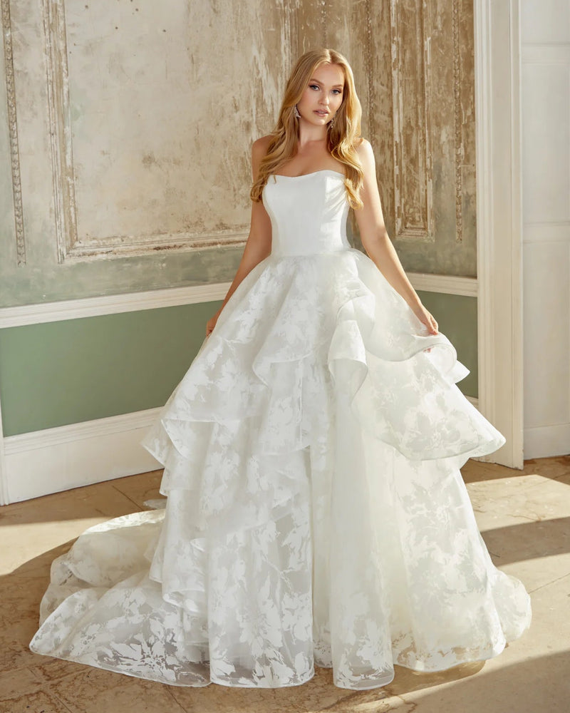 Woman in a white wedding dress standing in a room with decorative walls.